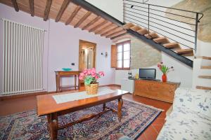 a living room with a table and a staircase at Podere Campriano Winery in Greve in Chianti