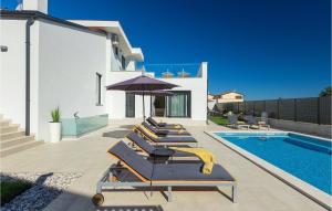 a row of lounge chairs next to a swimming pool at Villa Dolcea in Umag