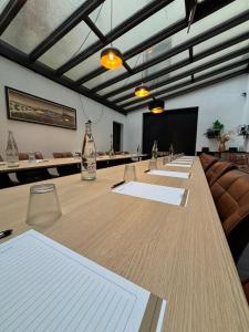 a conference room with a long table with chairs and a screen at Hôtel Le Valois, Cognac Centre in Cognac