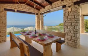 GrmaniにあるVilla Infinityの大きな窓のある部屋にある、食器が置かれた木製のテーブル