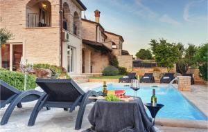 a patio with a table and chairs next to a pool at Villa Macun in Rovinj