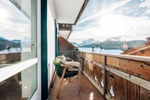 a balcony with a chair and a view of the water at le Gemme - Dolomites escape in Dosoledo