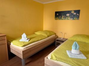 two beds in a yellow room with hats on them at Ferienwohnungen Alte Bäckerei in Rostock