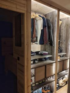 La Cabane Charmant T2 avec jardin centre village في سان جيرفيه ليه بان: خزانة ملابس مليئة بالملابس والأحذية