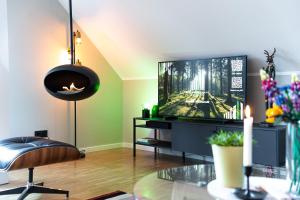 sala de estar con TV y silla en Waldbewohner Apartments / Hirsch, en Ilsenburg