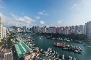 ein Fluss voller Boote in einer Stadt in der Unterkunft The Aberdeen Harbour by Ovolo in Hongkong