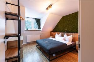 Un dormitorio con una cama con una pared verde. en Waldbewohner Apartments / Hirsch, en Ilsenburg