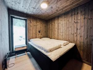 a bedroom with a bed in a wooden wall at Modern Mountain Cabin - Sauna - 5 Bedrooms - Sleeps for 10 in Torpo