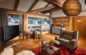 a living room with a flat screen tv and a couch at Kitzhof Mountain Design Resort in Kitzbühel