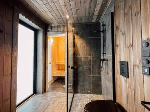 a bathroom with a shower with a glass door at Modern Mountain Cabin - Sauna - 5 Bedrooms - Sleeps for 10 in Torpo +47 photos