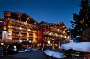 a large building with lights on it in the snow at Kitzhof Mountain Design Resort 4 Sterne Superior in Kitzbühel