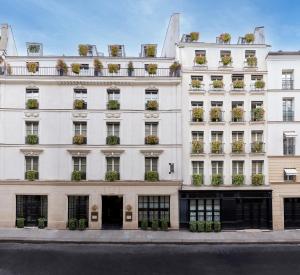 a white building with potted plants on the windows at Le Burgundy Paris in Paris