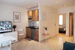 uma sala de estar com uma cozinha e uma sala de jantar em Jardin Saint Honoré Apartments em Paris
