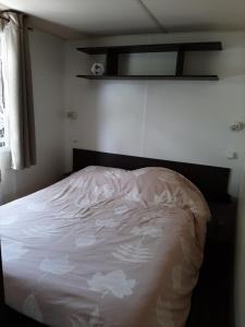 un dormitorio con una cama con sábanas blancas en Mobilhome Mobil home Cap ferret, en Claouey 4 fotos más