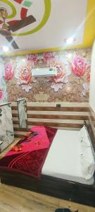 范兰德凡K D Dham Near Prem Mandir Iskcon temple Vrindavan的一间设有床铺和鲜花的墙壁的房间
