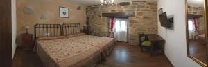 a bedroom with a bed and a stone wall at La Posada de Pedrazales in Pedrazales