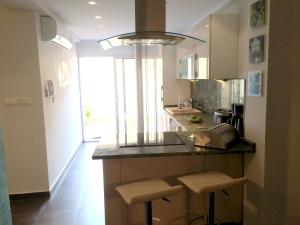 a kitchen with a counter with stools in it at Apart Mahdia in Mahdia