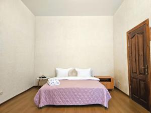a bedroom with a large bed with a purple blanket at Однокімнатна квартира біля ЦУМу в центрі Полтави Документи для відряджень Безконтатне заселення 24-7 in Poltava +20 photos