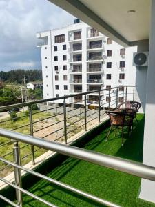 einen Balkon eines Gebäudes mit einem Tisch und Stühlen in der Unterkunft Aqua Luxury homes in Mombasa