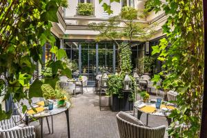 an outdoor patio with tables and chairs and plants at Le Burgundy Paris in Paris