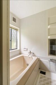 a white bathroom with a tub and a window at Foresta Karuizawa 3 in Miyota