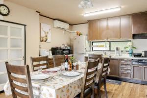 a kitchen with a table and chairs and a kitchen with a refrigerator at Foresta Karuizawa 3 in Miyota