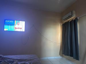 una camera da letto con una tv a parete e un letto di Casa para cop30 ad Ananindeua
