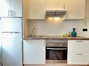 eine Küche mit weißen Schränken und einem Kühlschrank in der Unterkunft YBH Doctor Cadaval 10 A in Vigo + 2 Fotos