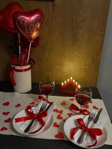 a table with two plates and two glasses of wine at Apartmani Viver Vrnjačka Banja in Vrnjci
