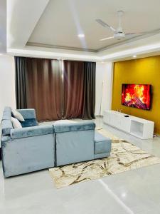 ein Wohnzimmer mit einem blauen Sofa und einem Gemälde in der Unterkunft Aqua Luxury homes in Mombasa