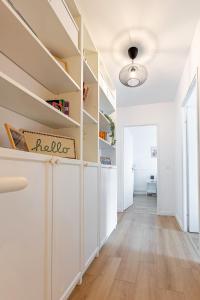 a hallway with white walls and white shelves at Le Duplex des Docks by So Homy - 2 Bed Room - 4 PAX in Saint-Ouen