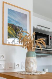 a vase sitting on a table with a plant in it at Le Duplex des Docks by So Homy - 2 Bed Room - 4 PAX in Saint-Ouen