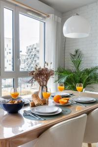 un tavolo da pranzo con arance e pane sopra di Le Duplex des Docks by So Homy - 2 Bed Room - 4 PAX a Saint-Ouen