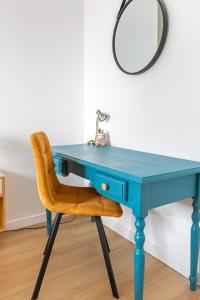 una scrivania blu con sedia e specchio di Le Duplex des Docks by So Homy - 2 Bed Room - 4 PAX a Saint-Ouen Altre 45 foto