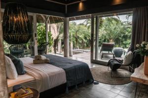 a bedroom with a large bed and a patio at Rimba by Hari Indah in Uluwatu