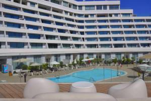 a large apartment building with a swimming pool and chairs at סי סייד אילת חדר משפחתי מפנק עם נוף לים in Eilat