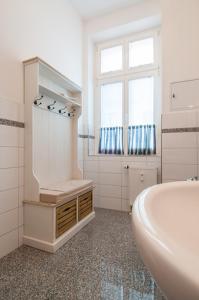 ein weißes Badezimmer mit einer Badewanne und einem Waschbecken in der Unterkunft Ferienwohnung Warnemünde - L (N) in Warnemünde
