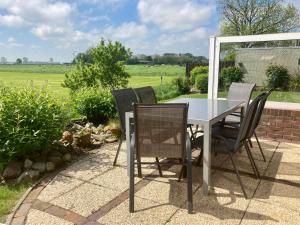 a table and chairs sitting on a patio at Huus ACHTERN DIEK by fewo-plan HORS115 an der Nordsee bei Horumersiel-Schillig in Wangerland