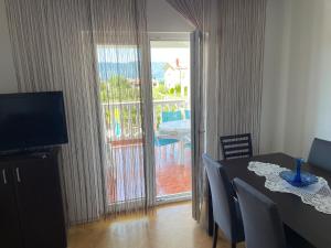 ein Esszimmer mit einem Tisch und Blick auf einen Balkon in der Unterkunft Haus ''Mira'' in Pinezici
