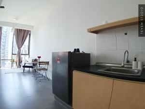 a kitchen with a sink and a refrigerator and a table at Five Studio - Empire Damansara in Petaling Jaya