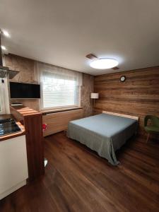 a bedroom with a bed and a window and a kitchen at Cozy 1 room flat with sauna in Komárno +12 photos