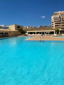 a large blue swimming pool in front of a building at Praia da Rocha- PORTIMÃO Apartamento T1 in Praia da Rocha