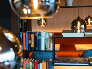 a book shelf filled with lots of books at JustStay Essen Hotel & Apartments in Essen