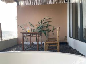 a bathroom with a table and two chairs and a plant at Seaside Mui Ne Hotel in Mui Ne