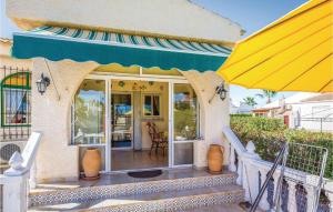 a house with a large yellow umbrella on a porch at Urb San Luis in Torrevieja