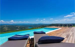 a swimming pool with chairs on a wooden deck at Villa Vista in Zamask