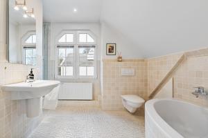 a bathroom with a sink and a tub and a toilet at CLS Moderne Villa Bad Schwartau mit Garten für bis zu 6 Personen, 2 E-Ladesäulen, 3 Parkplätze, Loggia, Big GREEN EGG, Massagesessel, großes Haus zwischen Lübeck und Ostsee, ideale A1 Anbindung nach Hamburg, Lübeck, Timmendorfer Strand in Bad Schwartau +25 photos