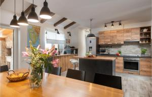 a kitchen with a wooden table with a vase of flowers at Villa Kalista Istriana in Pula