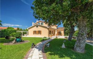 a large house with a tree in the yard at Villa Rosa Labin in Labin