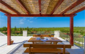Un patio con una mesa y bancos en una terraza. en Villa Veronika, en Pula